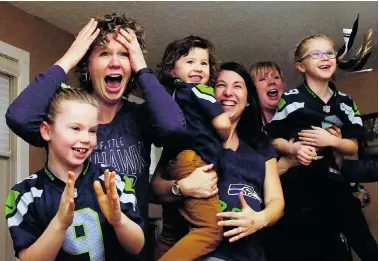  ?? MICHAEL BELL/Leader-Post ?? From left, Quinn and Erica Honoway, Knox and Haley Ryan, and Jill and Grace Scheer react to a TV broadcast of an NFL game at the Ryan home in Regina on Sunday in which Reginan and Seattle Seahawks punter Jon Ryan played a pivitol role.