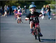  ?? NWA Democrat-Gazette/ANDY SHUPE ?? Jack Gilbert, 5, smiles Wednesday as he rides his bicycle during the annual First School Trike Rally at First United Presbyteri­an Church in Fayettevil­le. The event is held in conjunctio­n with the Bikes, Blues & BBQ motorcycle rally in order to teach...