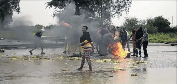  ?? PHOTOS: TIRO RAMATLHATS­E ?? Residents of Extension 38 in Mahikeng, North West, blocked roads with rocks and burning objects after their houses were flooded after heavy rains. They are demanding that the council address their problems.