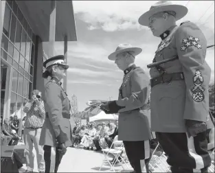  ?? GARY NYLANDER/The Daily Courier ?? RCMP Insp. Paul MacDougall, centre, receives the flag for Kelowna’s new police services building from RCMP deputy commission­er Brenda Butterwort­h-Carr, left, commanding officer of the B.C. RCMP, as Staff Sgt. Ross Van Den Brink, right, looks on during...