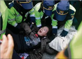  ?? CHUNG SUNG-JUN / GETTY IMAGES ?? Left: Police officers scuffle outside Park’s home in Seoul with protesters demanding her arrest Thursday. Park was jailed on Friday.