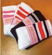  ?? KRISTEN KILPATRICK VIA THE NEW YORK TIMES ?? Tube socks were among the more than a dozen items in the gifting suite at an Eras Tour-themed welcome party at the wedding of the Taylor Swift fans Abby Argo and Phil Sprio in Vail, Colo. A growing number of couples are including gifting suites that allow their wedding attendees to pick a souvenir they’ll actually use. ONe guest said she “pretty much lives in” the sweatshift she chose.