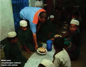  ??  ?? MOHD Johari menghidang­kan makanan kepada anak pelarian.