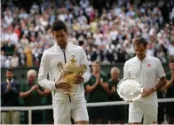  ?? AP Photo/Tim Ireland ?? ■ Novak Djokovic, left, and Roger Federer walk with the trophies after the men’s singles final Sunday at Wimbledon. Djokovic won the historic match to claim his second straight Wimbledon title.