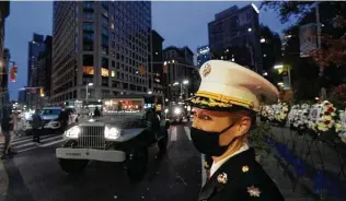  ?? Mark Lennihan / Associated Press ?? A Marine officer watches a 100-vehicle parade pass along Fifth Avenue on Wednesday in New York. The Veterans Day parade was held, with no spectators, to maintain the 101-year tradition.