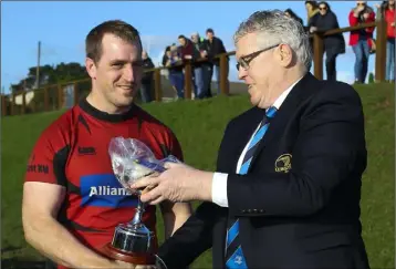  ??  ?? Robert Deacon of the Leinster Branch presents the cup to New Ross captain Steve Roche.