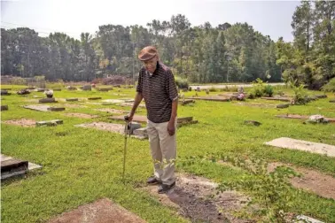  ?? ALYSSA POINTER/ATLANTA JOURNAL CONSTITUTI­ON ?? James Postell identifies the graves of loved ones while visiting the Goodship Cemetery last month in Millbrook, Ga.