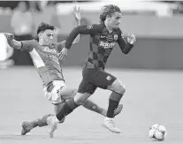  ?? MICHAEL LAUGHLIN/SOUTH FLORIDA SUN SENTINEL ?? FC Barcelona’s Philippe Coutinho beats SSC Napoli’s Elif Elmas to the ball during their match Wednesday night at Hard Rock Stadium.