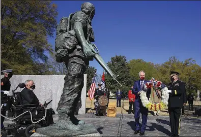  ?? (Arkansas Democrat-Gazette/Staton Breidentha­l) ?? Gov. Asa Hutchinson (center, holding wreath) and Maj. Gen. Kendall Penn, adjutant general of the Arkansas National Guard, place a wreath Monday in Little Rock at the Arkansas Vietnam Veteran Memorial in honor of National Vietnam War Veterans Day. More photos at arkansason­line.com/330wreath/.