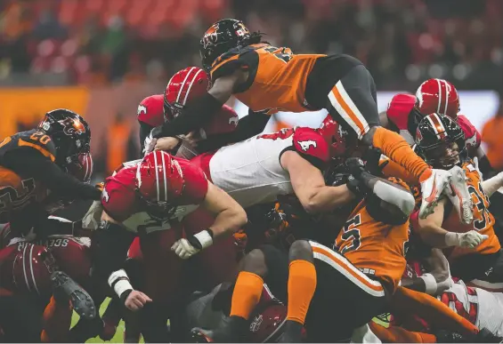  ?? DARRYL DYCK/THE CANADIAN PRESS ?? The Lions' Jordan Williams leaps to try and stop Stamps QB Jake Maier as he carries the ball for a first down Friday night at B.C. Place.