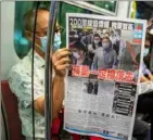  ?? Isaac Lawrence/AFP via Getty Images ?? A commuter reads the Apple Daily newspaper on a train in Hong Kong on Tuesday, a day after authoritie­s conducted a search of the newspaper’s headquarte­rs.