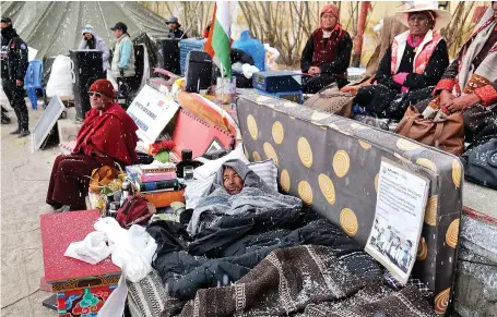  ?? CLIMATE CHANGE
AP ?? Sonam Wangchuk, lying under blankets, is surrounded by supporters on the 17th day of his hunger strike seeking protected status for the region’s people.