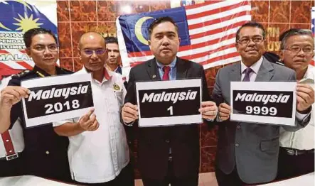  ?? PIC BY HAZREEN MOHAMAD ?? Transport Minister Anthony Loke (centre) and Road Transport Department director-general Datuk Shaharuddi­n Khalid (second from right) showing the ‘Malaysia’ series number plates at the RTD headquarte­rs in Seremban yesterday.