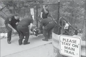  ??  ?? A woman is rescued by emergency personnel after injuring her leg at Albion Falls. Despite the chain-link fence around access points to the falls, numerous hikers were making their way around and through the barriers to access the falls, which has been...