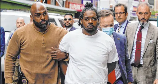  ?? Mary Altaffer The Associated Press ?? Andrew Abdullah is escorted into the Fifth Precinct in New York. Abdullah, the man wanted in an apparently unprovoked fatal shooting aboard a New York City subway train, surrendere­d to police Tuesday.