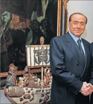  ??  ?? LA FIRMA. Momento en el que Silvio Berlusconi y Yonghong Li se hacen la fotografía tras