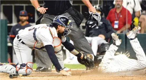  ?? AP ?? Tim Anderson beats the tag of Tigers catcher Eric Haase in the fourth inning Friday, extending the Sox’ lead to 4-1 in the opener of their final regular-season series.