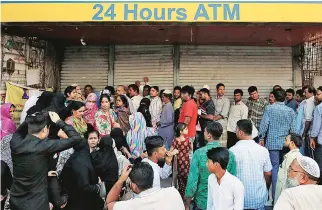  ?? FILE PHOTO REUTERS ?? People queue outside a bank to withdraw cash and deposit their old high-denominati­on banknotes in Mumbai