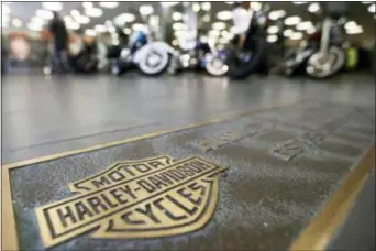  ?? KEITH SRAKOCIC — THE ASSOCIATED PRESS FILE ?? In this file photo, rows of motorcycle­s are behind a bronze plate with corporate informatio­n on the showroom floor at a Harley-Davidson dealership in Glenshaw, Pa. Harley-Davidson, facing rising costs from new tariffs, will begin shifting the...