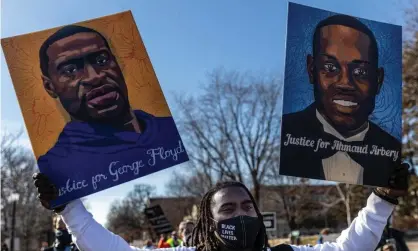  ?? Photograph: Kerem Yucel/ AFP/Getty Images ?? A protester holds placards with pictures of George Floyd and Ahmaud Arbery in St Paul, Minnesota, this month.