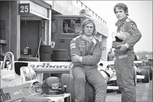  ?? Associated press ?? ABOVE: This image released by Universal Pictures shows Chris Hemsworth, left, and Daniel Bruhl in a scene from “Rush.” LEFT: This image released by Universal Pictures shows director Ron Howard on the set of “Rush.”