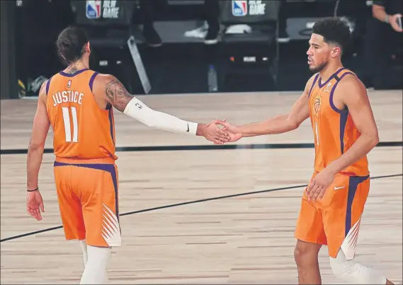  ?? FOTO: AP ?? Ricky Rubio, con la palabra ‘Justice’ (Justicia) en su camiseta, junto a Devin Booker en el encuentro que los Suns disputaron frente a los Wizards en la ‘burbuja’ de Orlando