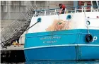  ?? AP ?? A crew member cleans marks from the stern of the Honeybourn­e 3, a Scottish scallop dredger, attacks by French fishing vessels.