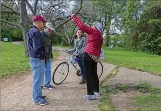  ??  ?? Amy Belaire, with the Nature Conservanc­y, speaks with bird watchers Tom Schmitt, Jimmy Stanley and Barbara Felkins in the Waller Creek and Lake Austin area.