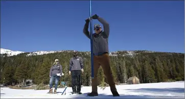  ?? RICH PEDRONCELL­I — THE ASSOCIATED PRESS ?? Sean de Guzman, right, chief of snow surveys for the California Department of Water Resources, plunges the snow survey tube into the snowpack as DWR’s Chief of State Water Project Operations Molly White, left, and Water Resources Engineer Nathan Burley, center, look on at Phillips Station near Echo Summit on Thursday. The survey found the snowpack at 29 inches deep with a water content of 11.5 inches at this location.