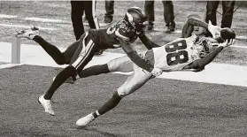  ?? Jim Mone / Associated Press ?? Cowboys rookie receiver CeeDee Lamb extends past Vikings cornerback Jeff Gladney for a 4-yard touchdown catch during the first half Sunday.