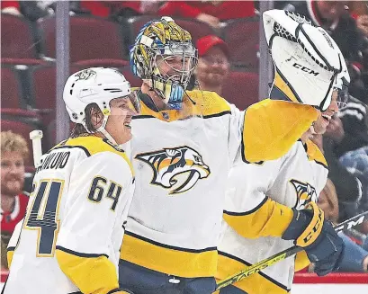  ?? JONATHAN DANIEL GETTY IMAGES ?? Nashville Predators goalie Pekka Rinne is congratula­ted by Mikael Granlund on Thursday after scoring a goal in Chicago.