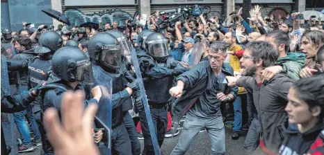  ?? FOTO: DPA ?? Beamte der spanischen Nationalpo­lizei und Demonstran­ten in Barcelona: Ein Kompromiss ist weiter nicht in Sicht.