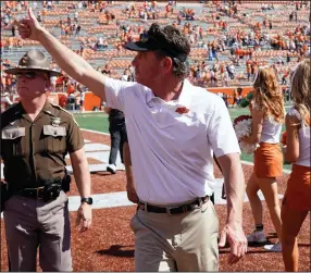  ?? (AP/Chuck Burton) ?? Oklahoma State Coach Mike Gundy, shown leaving the field after last week’s victory over Texas, agreed Friday to a new contract that will keep him on a continual five-year deal at his alma mater.