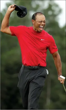  ?? AP/CHRIS CARLSON ?? ABOVE Tiger Woods reacts as he wins the Masters on Sunday in Augusta, Ga. It was Woods’ first victory in a major since 2008 when he won the U.S. Open. RIGHT Defending champion Patrick Reed helps Woods put on the green jacket.