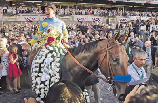  ?? Peter Foley European Pressphoto Agency ?? VICTOR ESPINOZA and American Pharoah get to the winner’s circle after the horse becomes the 12th Triple Crown champion with a Belmont Stakes victory. A1