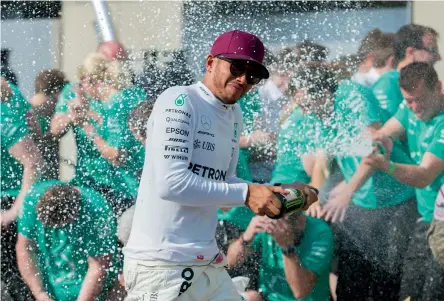  ??  ?? Mercedes’ Lewis Hamilton sprays his crew with champagne after winning the Canadian Grand Prix in Montreal on Sunday.