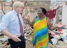  ??  ?? Mr Johnson with a resident in the battered Caribbean yesterday