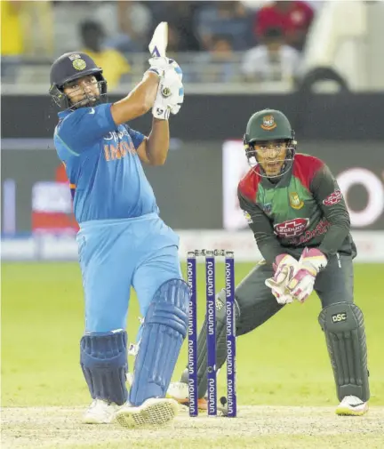  ?? (Photos: AFP) ?? Indian Cricket team captain Rohit Sharma (left) plays a shot as Bangladesh wicketkeep­er Mushfiqur Rahim looks on during the One Day Internatio­nal Asia Cup cricket match at the Dubai Internatio­nal Cricket Stadium in Dubai yesterday.