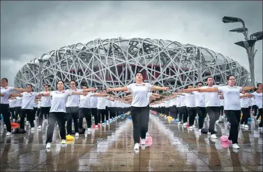  ?? HUANG LIANG / FOR CHINA DAILY ?? Residents put on a group exercise at an event on Wednesday in front of the Bird’s Nest stadium marking the 10th anniversar­y of the Beijing Olympic Games’ opening in 2008. The event also marked China’s 10th National Fitness Day.