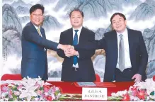  ?? Courtesy of Hanon Systems ?? Hanon Systems CEO Lee In-young, left, poses with Chongqing Jianshe Mechanical and Electrical Equipment Chairman Li Hua Guang, center, and Chongqing Jianshe Motorcycle Chairman Lu Hong Xian during a joint venture signing ceremony in Beijing, Oct. 25.