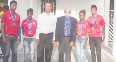  ??  ?? President of the Guyana Olympic Associatio­n (GOA), K Juman-Yassin and President of the Athletic Associatio­n of Guyana (AAG), Aubrey Hutson pose with some of the medalists which returned from a successful CARIFTA Games sojourn in Curacao Friday