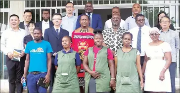  ?? ?? Minister of Labour and Social Security Phila Buthelezi (in traditiona­l regalia) and his team posing for a group photo with Tex Ray Group of Companies management and workers after the courtesy vist by the minister yesterday.