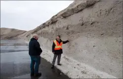  ?? THE CANADIAN PRESS/RYAN REMIORZ ?? City spokesman Philippe Sabourin, right, looks at the mountain of snow at the Angrignon dump, which is 90 percent full, as snow removal operations continue Wednesday, in Montreal.