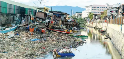  ?? SUNSTAR FOTO/ARNI ACLAO ?? SHRINKING RIVER. The Guadalupe River exits through Barangays Pasil (left) and Ermita in Cebu City, much narrowed by the encroachme­nt of houses and trash on its banks. Is it any wonder that when heavy rains come, the river overflows?