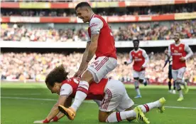  ??  ?? Granit Xhaxa takes a ride on David Luiz after the Brazilian put Arsenal 1-0 up against Bournemout­h. Photograph: Neil Hall/EPA