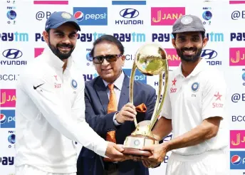  ?? — AFP photo ?? India’s cricket captain Virat Kohli (left) and Ajinkya Rahane (right) receive the Border-Gavaskar tropy from Sunil Gavaskar during the fourth day of the fourth and final cricket Test match between India and Australia at The Himachal Pradesh Cricket Associatio­n Stadium in Dharamsala, in this March 28, 2017 file photo.
