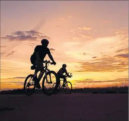  ??  ?? Silhouette­d cyclists enjoy a peaceful run-out at sunset