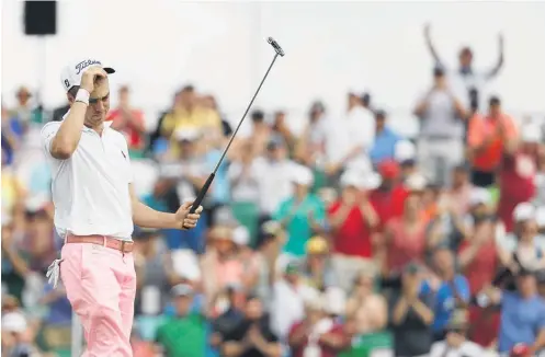  ?? Picture / AP ?? Justin Thomas acknowledg­es the crowd after his eagle putt on the 18th saw him score 63 and move with one of the lead.