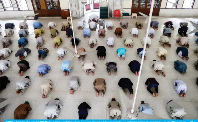  ?? — AFP ?? KARACHI: In this picture taken on April 19, 2020, Muslims maintain social distancing during noon prayers at a mosque during a government-imposed nationwide lockdown as a preventive measure against the coronaviru­s.