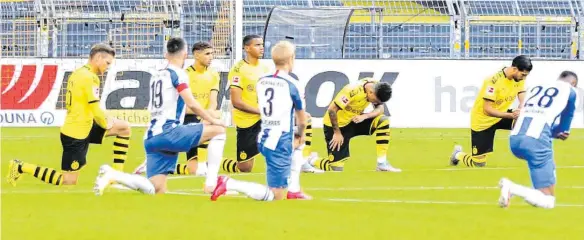  ?? FOTOS: LARS BARON/AFP ?? Ein Kniefall als Zeichen – Viele Fußballer, darunter die Spieler von Borussia Dortmund und Hertha BSC, schlossen sich den Protesten nach dem gewaltsame­n Tod von George Floyd an.